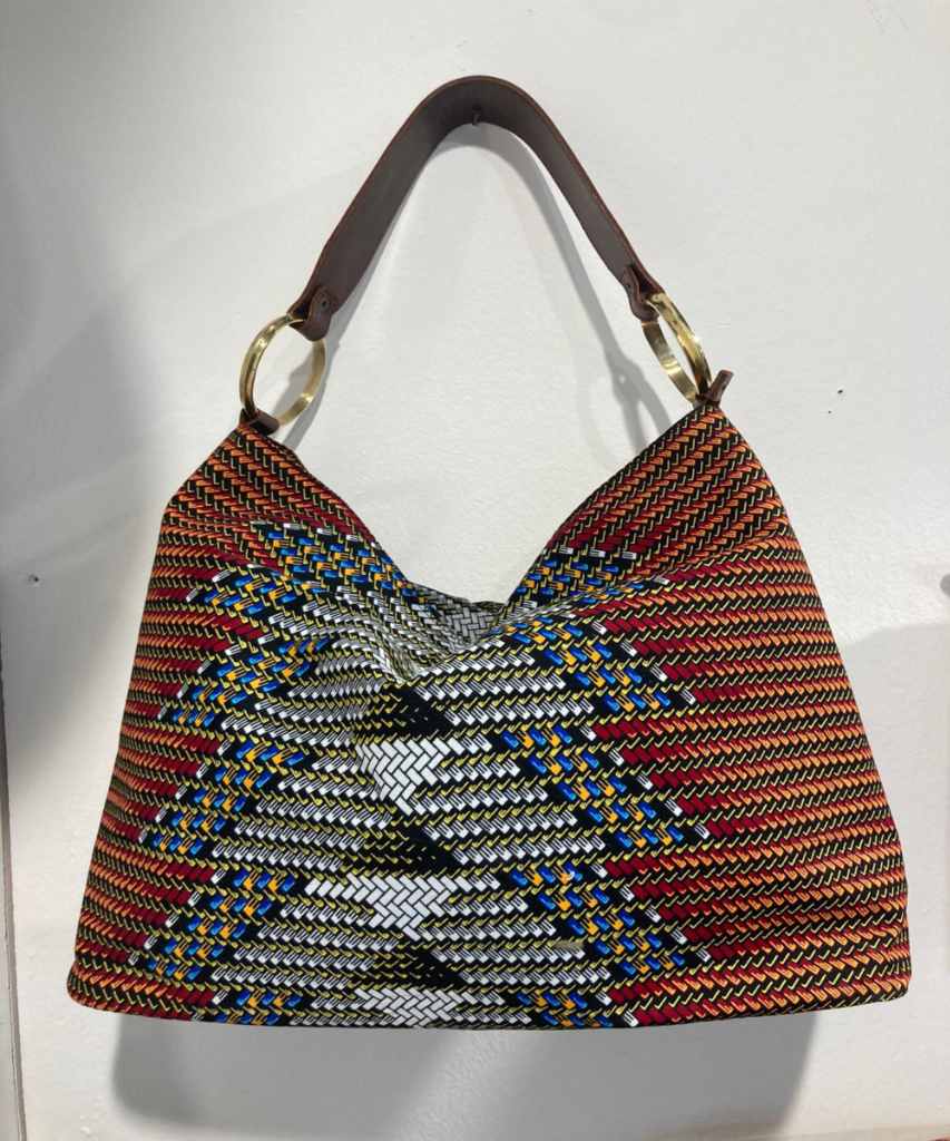 Borsa in pelle e tessuto con motivo tessile multicolore, base e manico in pelle e anelli dorati, progettata e spedita dall’Italia.